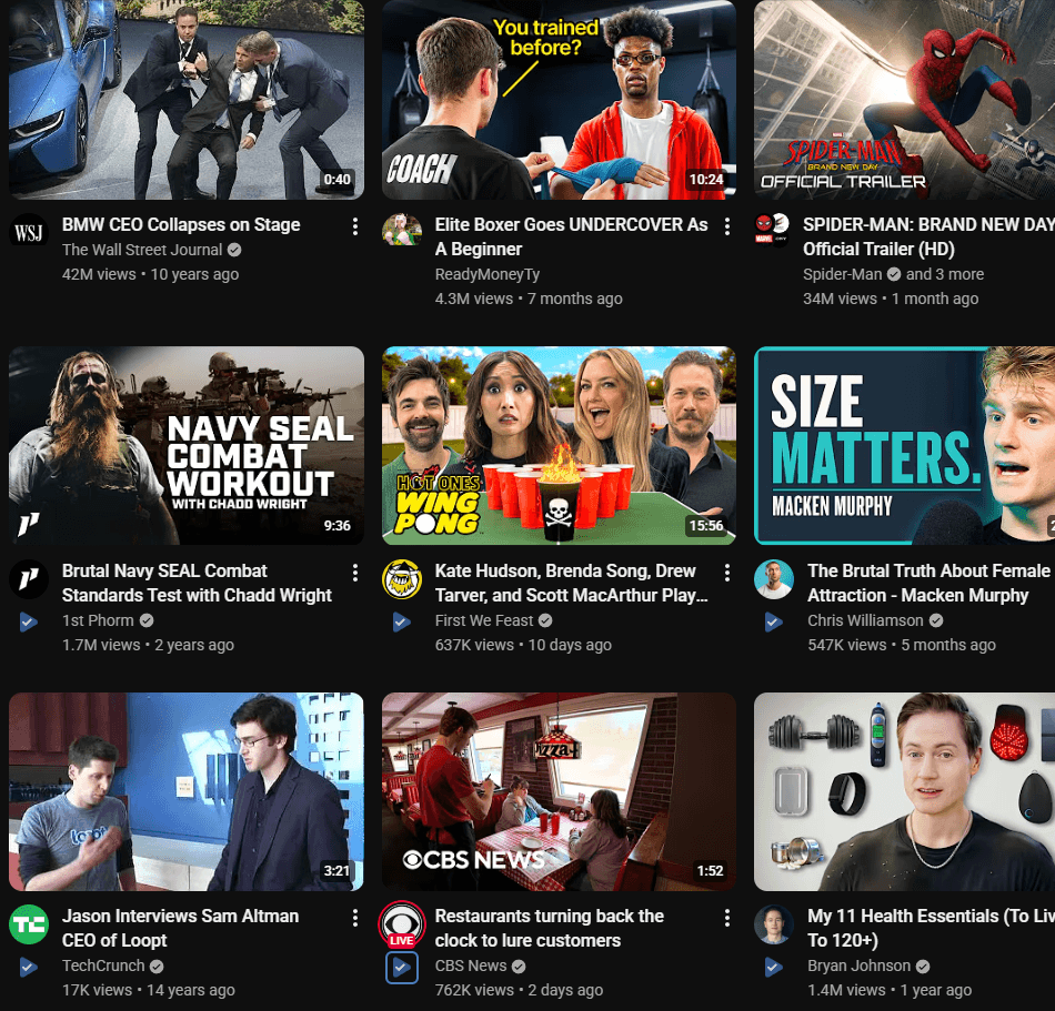 A YouTube feed where each video has a VidScore badge under its title. Some show a blue check because they are already scored, others show a grey arrow because they are not.